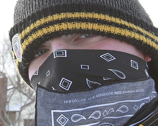 William D. Lewis the Vindicator  Haeden Gump, a student in Girard, keeps his face covered with a bandana  while spending a snow  trying to make a few dollars shoveling snow along Ward Ave. in Girard Wed 1-7-15. Cold temps, high wind and snow gave him plenty to do.