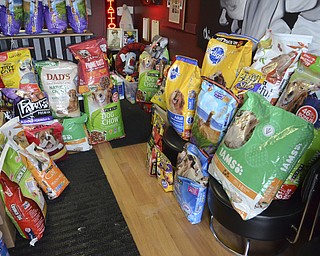 Katie Rickman | The Vindicator .Donated animal food and other animal products are stacked inside Chinebox Ink in Austintown where owner Aaron Chine has been collecting goods to donate to local charities.