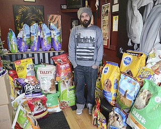 Katie Rickman | The Vindicator.Aaron Chine of Chinebox Ink in Austintown stands in a room lined with donated animal food, treats, and other products on Thursday afternoon. Five animal charity groups split the donations and collected them on Thursday afternoon.