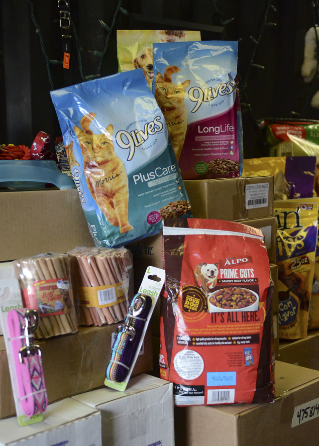 Katie Rickman | The Vindicator .A pile of donated animal food and other animal products are stacked inside Chinebox Ink in Austintown where owner Aaron Chine has been collecting goods to donate to local charities.