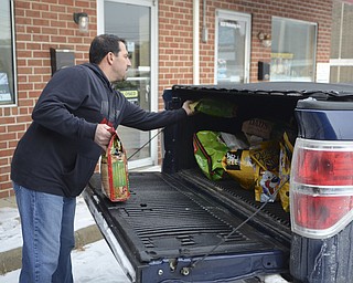 Katie Rickman | The Vindicator.Dan Cipriano of Legacy Dog Rescue puts donated dog food in the back of his truck at Chinebox Ink in Austintown Thursday afternoon.  Aaron Chine has been collecting donated goods for local rescues.