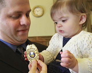 William D Lewis the vindicator YPD officer Chad Zubal looks on as his daughter Alexa Lynn, 17 months, checks out his badge during a promotion ceremony 1-8-15 in city council chambers. He was promoted from patrolman to detective sgt. also promoted was Ramon Cox from detective to lieutenant.
