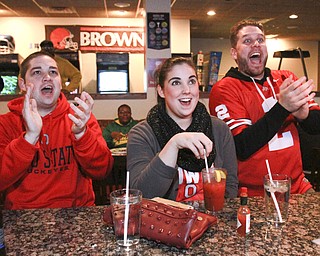 William D. Lewis The Vindicator  OSU fans from left, Todd Prodnick Lauren Hunkis and Bobby Prodnick, all of Girard watch OSU game at Martini Brothers Burger Bar in Youngstown 1-12-15.