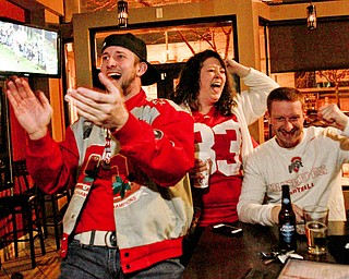 William D. Lewis The Vindicator  OSU fans from left, Matt Firment of McDonald, Ashley Hoffman of Vienna, Joe Murray of Youngstown watch OSU game at V2 in Youngstown 1-12-15.