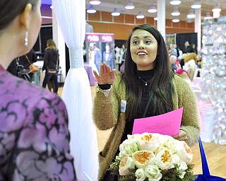 Jeff Lange | The Vindicator  Chelsie King (right) of New Wilmington discusses flowers with Claudia Fantauzzi of Royal Weddings Sunday afternoon prior to the start of the 2015 Bridal Extravaganza Fashion Show at the Eastwood Mall.