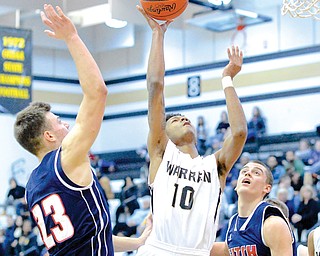 Warren Harding’s Jarelle Johnson (10) looks to the basket between Fitch defenders Zac Carr (23) and Dominic
DiFrancesco (32) in the fourth period of their game Tuesday in Warren.