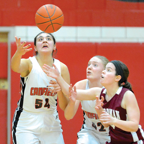 Boardman’s Lauren Pavlansky and Canfield’s Emily Ellis (54) and Erin Risner (42) all make a play for a rebound during the second half of their All-American Conference game Wednesday at Canfield High School. The Cardinals downed the Spartans, 56-34.