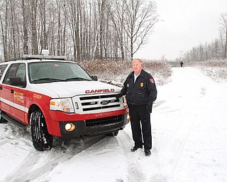 Don Hutchison, Cardinal Joint Fire District chief, stands in front of the emergency road connecting the Westbury Park and Stonebridge developments in Canfield. The middle point of the route is about where the person is standing in the distance. The extension will connect both sides of Timber Run Drive.
