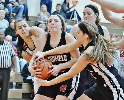Jeff Lange | The Vindicator  Howland's Trisha Ginnis (left) and Canfield's Savannah Barko (right) attempt to rip the ball from the arms of Canfield's Jill Baker during their game at Howland High School, Saturday afternoon.