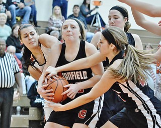 Jeff Lange | The Vindicator  Howland's Trisha Ginnis (left) and Canfield's Savannah Barko (right) attempt to rip the ball from the arms of Canfield's Jill Baker during their game at Howland High School, Saturday afternoon.