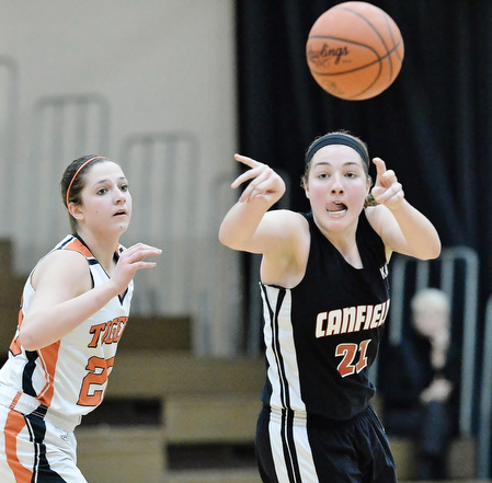 Jeff Lange | The Vindicator  Canfield's Rachel Tinkey (21) makes a pass to a teammate in front of Howland's Sara Price during fourth quarter action of Saturday afternoon's game in Howland.