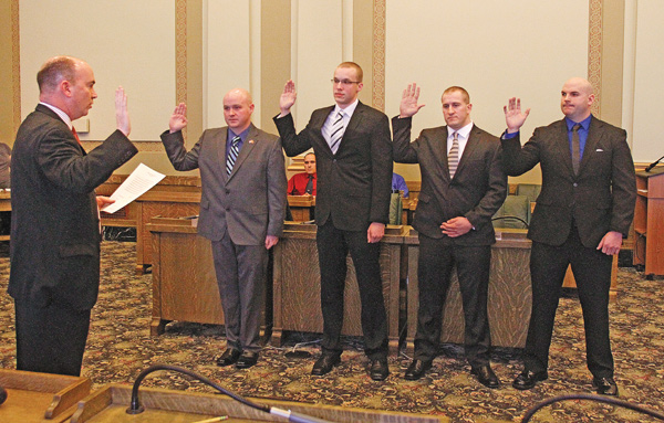 Youngstown Mayor John McNally, left, swears in four new members of the city police department Monday: Brandon Caraway of McDonald, left, Mark Sember of Howland, Jeffrey Savnik of Youngstown and Chase Lemke of Austintown.