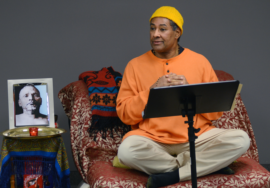 Katie Rickman | The Vindicator.Kedar Acharyaji speaks at a chanting and meditation program at Bella Nitesh on Jan. 14, 2015 with a portrait of Bhagawan Nityananda (a Siddha Guru or Profected Master) to his left. Over a dozen people gathered to hear Acharyaji speak about finding inner peace and power within..