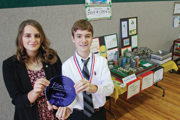 Paige Brockway and Matthew Rossi, eighth-grade students at Holy Family School in Poland, hold the second-place trophy from the Future City Competition. Brockway and Rossi, along with a group of more than 20 other sixth-, seventh-, and eighth-grade Holy Family students, chose Youngstown as the city they would design in its future form. The competition asks participants to design a city, research a solution to a social problem and then build a model of the city using recycled materials. This was Holy Family’s best year in the state competition.