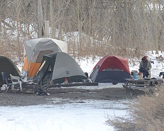 Katie Rickman  | The Vindicator.A small "tent city" under Marshall Street Bridge where several homeless people live is viewed from West Front Street in Youngstown on January 15, 2015. A man stands next to a picnic table near the tents.