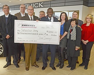 Katie Rickman | The Vindicator.Board members  the Salvation Army Red Kettle Campaign of the Mahoning Valley pose with Doug Sweeney and other Sweeney workers during a check presentation at Sweeney Cheverlet Buick GMC on Thursday, Jan. 15, 2015...L-R.Fred Still Wagon (Salvation Army), Dave Baker (Sweeney CFO) Doug Sweeney, Paul Pirko (Salvation Army), Maj. Elijah Kahn (Salvation Army), Alexa Sweeney, Derek Snyder (Sweeney employee), Carol Baird (Salvation Army) and Stephanie Landers (Salvation Army)