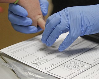        ROBERT K. YOSAY  | THE VINDICATOR..school resource officer Steve Garstka puts the fingerprints for the student.  The fingerprints are not put on file but rather sent home to the parents...officer as part of a PTA/School/ and Canfield PD initiative... students in k-4 in the Canfield Schools will have an Identity Kit done in school with their fingerprints and then sent home to the parents.