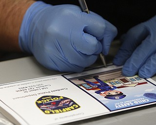        ROBERT K. YOSAY  | THE VINDICATOR..school resource officer Steve Garstka fills in the identity folder before the students have their fingerprints taken..officer as part of a PTA/School/ and Canfield PD initiative... students in k-4 in the Canfield Schools will have an Identity Kit done in school with their fingerprints and then sent home to the parents.