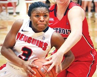 Youngstown State’s Indiya Benjamin tries to get past Detroit’s Ellisha Crosby during their Horizon League game Wednesday at YSU’s Beeghly Center. The Penguins allowed a 16-point lead to slip away and fell 59-58 to the Titans.