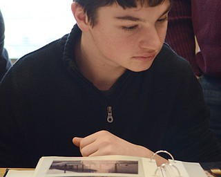 Katie Rickman | The Vindicator.Jack Bajerski looks through a picture album featuring photos from previous Ohio American Legion student trips to Washington DC on Thursday, Jan. 23, 2015 at South Range High School.