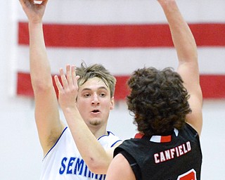Jeff Lange | The Vindicator  Poland's Kyle Dixon (facing) makes pass to a teammate over Canfield's John French (13) in the fourth quarter of their game, Friday night in Poland.