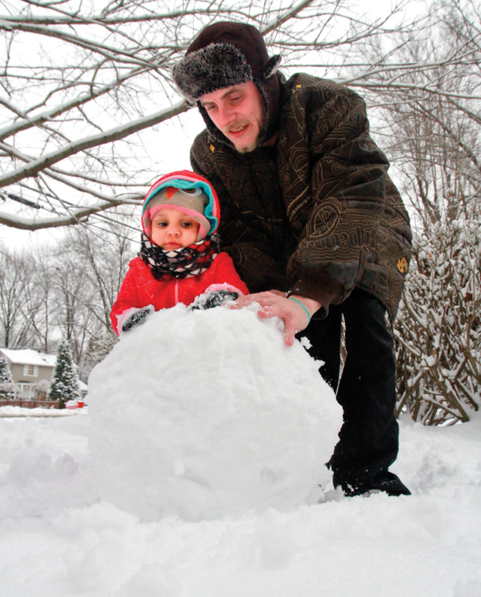 Robert Reed and his daughter Natalee Reed, 2, build a snowman in the front yard of their Arden Blvd. home in Youngstown Sunday, February 1, 2015.