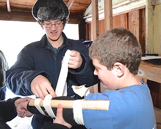Jeff Lange | The Vindicator  James Reardon (age 16) of Troop 49 Road Runners in New Middletown (facing) splints Tyler Roman's (age 12) arm during the first aid activity at Camp Stambaugh during the annual Klondike Derby, Saturday afternoon.