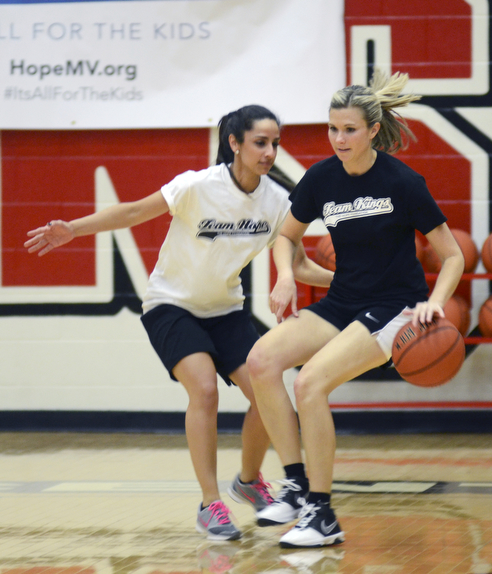 Katie Rickman | The Vindicator.Team Kings Lisa Stroney (#21) moves up court team Hope's Cristina Esparra (#27) guards her during the first half of the Game of Hope charity event on Feb. 8, 2015 at YSU.