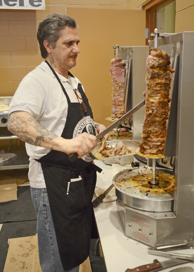 Katie Rickman | The Vindicator.Dino Diamantis of Campbell cuts meat off of a skewer to prepare a traditional gyro called Souvlaki during the first night of the Greek Festival at Archangel Michael Greek Orthodox Church in Campbell on Friday, Feb. 13, 2015.