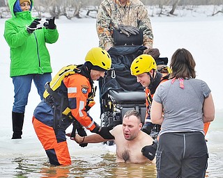 Jeff Lange | The Vindicator  Army veteran Brett Clingan is lowered into the freezing water at the start of the Polar Plunge at Mosquito Lake, Saturday afternoon. Brett has leukodystrophy a neurological disorder of the brain.