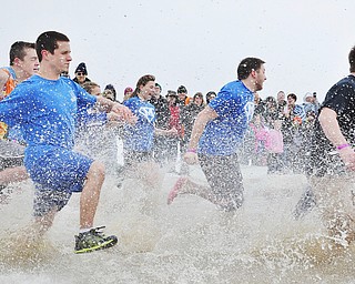 Jeff Lange | The Vindicator  James Miller of Maplewood High School (left) runs into the water with a group of students during Saturday's Polar Plunge at Mosquito Lake.