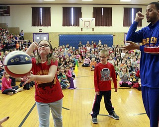 William D Lewis The Vindicator Harlem Globetrotter Zues McClurkin, a native of Columbus, Ohio, teaches a basketball trick to  Champion elem school students Sadie Rogers, 4th grade, left, and Ethan Laslo, 2nd grade during a 1-26-15 presentation at their school. The trotters will be at the Covelli Thursday night.