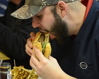 Katie Rickman | The Vindicator.James Chismark eats the Dave Growl Alley Burger during the Burger Guyz visit to the Courthouse Grill in Warren on Wednesday, Jan. 28, 2015.