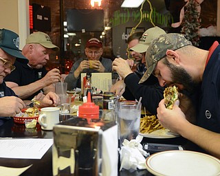 Katie Rickman | The Vindicator.JT Tranovich eats a sweet potato chip with his burger “The Deputy” during the Burger Guyz visit to the Courthouse Grill in Warren on Wednesday, Jan. 28, 2015.