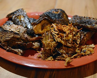Katie Rickman | The Vindicator.Brother in Food writers  Mike Vallas and Mark Smesko visited the Fire Grill in Girard on Thursday, Jan. 29, 2015. Featured here are their signature combo platter ÒCampire ComboÓ which features 1/3 rack of ribs, 1/4 BBQ chicken or 1/4 lb of pulled pork, texas hot link sausages or Hickery smoked jalepeno-cheddar plate of fries, and two jalepeno cornbread muffins.