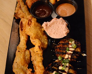 Katie Rickman | The Vindicator  .A sample platter featuring a little bit of everything from the appetizer menu at Fire Grill in Girard. Featured on platter: fried green tomatos, pigs in a basket (deep fried bettered bacon) Hushpuppies, and Frickled Pickles (dill pickles deep fried).