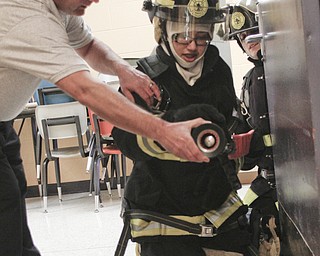        ROBERT K. YOSAY  | THE VINDICATOR..Capt  Jim Sapp instructor and YFD  teaches Rick Alli (front with nozzle and Kristen Bowman how to feel for heat before opening a door...A new program at Choffin Career and Technical Center teaches students fire fighting skills and techniques while aiming to increase the number of Youngstown residents in the fire department ranks..