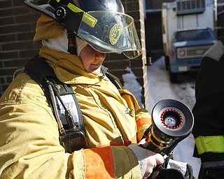        ROBERT K. YOSAY  | THE VINDICATOR..fastening the nozzle to the hose is Makala Shultz .A new program at Choffin Career and Technical Center teaches students fire fighting skills and techniques while aiming to increase the number of Youngstown residents in the fire department ranks..