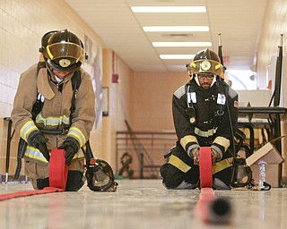        ROBERT K. YOSAY  | THE VINDICATOR..Dionshay Taylor  and Christopher Stevens roll up the hoses..A new program at Choffin Career and Technical Center teaches students fire fighting skills and techniques while aiming to increase the number of Youngstown residents in the fire department ranks..