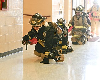        ROBERT K. YOSAY  | THE VINDICATOR.. Cadets learn to duck walk or crawl to the fire.. because smoke and less oxygen up high....A new program at Choffin Career and Technical Center teaches students fire fighting skills and techniques while aiming to increase the number of Youngstown residents in the fire department ranks..