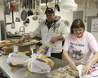 William D. Lewis The Vindicator  VolunteersTim Wilson of Vienna and Sharon Steed of Warren sort frozen foods during a food give away at Pleasant Valley Church in Liberty.