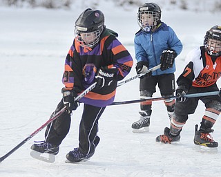 Katie Rickman | The Vindicator.L-R.Joe Kenneally, 9 of East Palestine, William Craven, 7 of Poland, and Lukas Black, 7 of Beliot play hockey on the Lilly Pond on Saturday, Jan. 31, 2015. Kenneally is a part of the Youngstown Phantoms Squirt hockey team and the other boys are apart of the Youngstown Phantoms Mite team.