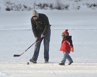 Katie Rickman | The Vindicator.Tre' Black entertains his 2-year-old son Case Black while his other son plays hockey on the Lilly Pond at Mill Creek MetroParks on Saturday, Jan. 31, 2015.