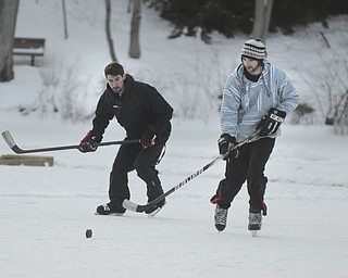 Katie Rickman | The Vindicator.Youngstown State University seniors Joe Crum of Youngstown (on left) and Breland Cockrell of Boardman play a quick game of hockey on the Lilly Pond at Mill Creek MetroParks on Saturday, Jan. 31, 2015.