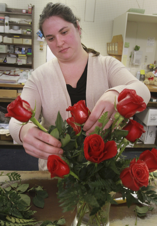 William D. Lewis the vindicator Danielle Rydarowicz, an employee of Dick Adgate Florist, Boardman, prepares an arrangement of roses 2-2-15.