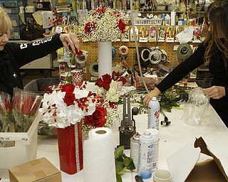 Maryann Sayavich (left) and her daughter Jennifer Sayavich put together flower bouquets at Sweet Arrangements florists in Youngstown on Saturday morning.   Dustin Livesay  |  The Vindicator  1/31/15  Sweet Arrangements, Youngstown.