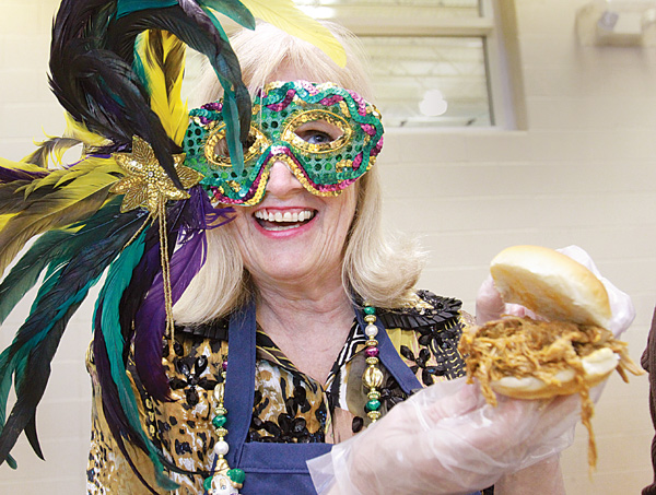 Liz Shutler shows off a pulled-pork sandwich she was serving during Fat Tuesday — Feed the Salem Community
Food Pantry at the Salem Community Center. Local businesses and organizations donate food to the annual
event, which raises money at $10 a plate.
