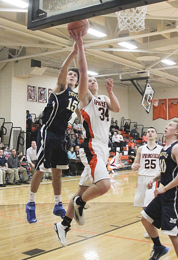 Springfield’s Brandon Chamberlain goes for a layup against McDonald’s Jake Reckard during the first quarter
of their game Tuesday at Springfield High School in New Middletown. Chamberlain scored 12 points for the Tigers, who earned their 20th straight victory with a 70-56 win over the Blue Devils. Springfield’s Graham
Mincher had a game high 24 points. High scorer for McDonald was Brad Woodley, who had 22.