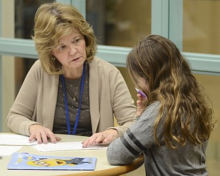 Katie Rickman | The Vindicator.Diana Ghizzoni, student council advisor for Poland High School students explains a math problem to Hannah Masucchi an 11-year-old student from Poland Middle School during an after school tutoring program on Wednesday, Feb. 4, 2015.