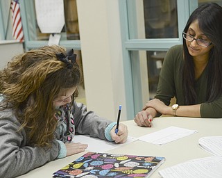 Katie Rickman | The Vindicator.Sophia Diamandis 11 of Poland works on math problems as Misha Mathur 18 (Student Council President) assists her during a tutoring session February 4, 2015.
